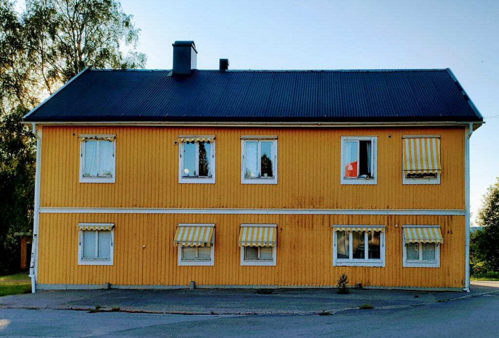 Keltainen kaksikerroksinen puurakennus