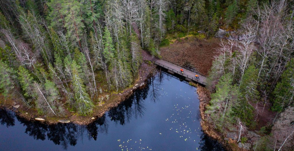 Ilmakuva South by Cycle -reitistöltä, kaksi pyöräilijää sillalla