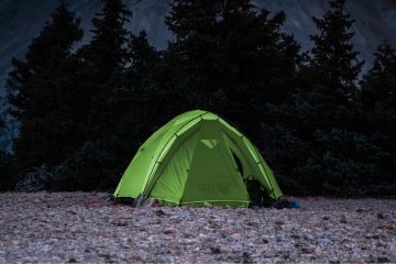 Iso teltta pystytettynä metsän reunaan