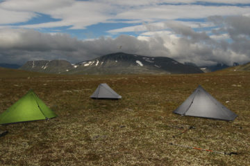 Kolme kevyttä telttaa vuoristomaisemassa